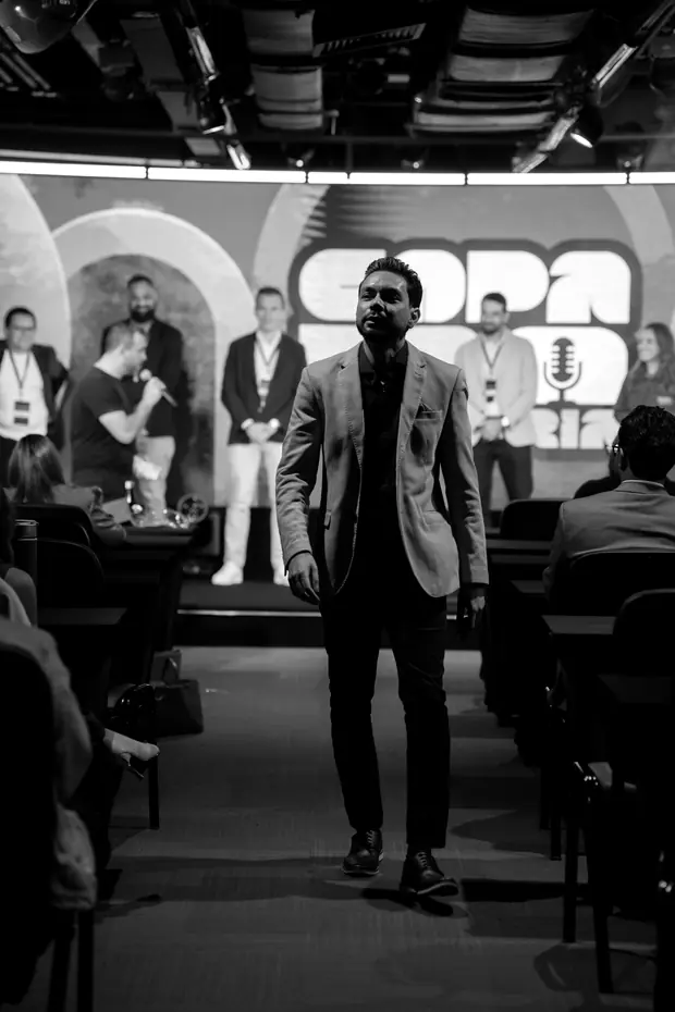 Airton Motta caminhando pelo corredor do evento em direção ao palco