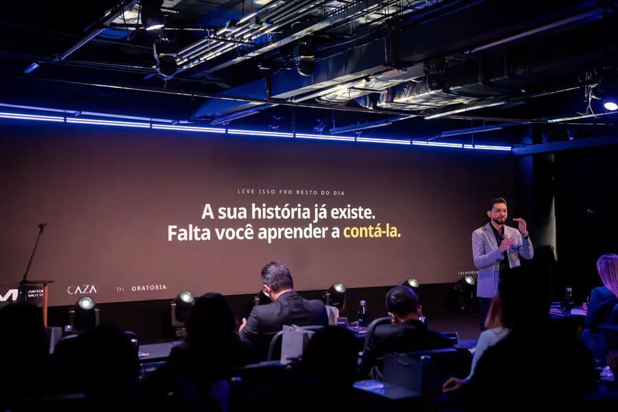 Apresentação no palco com a mensagem projetada no telão