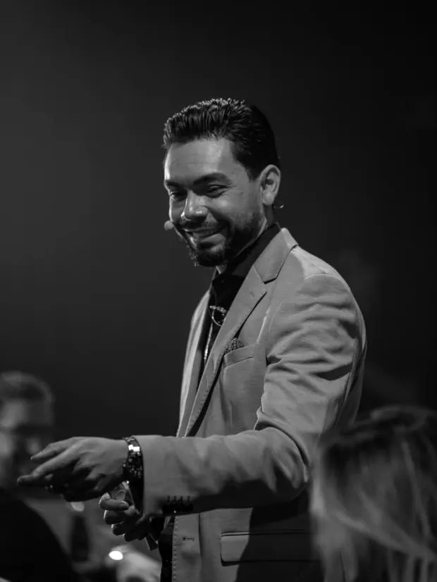 Airton Motta no palco do Comunica Experience, sorrindo e se dirigindo à plateia
